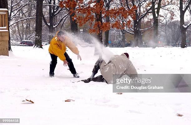 Patrick O'brien and Chris Lewis, staffers from the Russell Senate Office Building enjoy a snow ball fight during the first snow storm of the winterin...