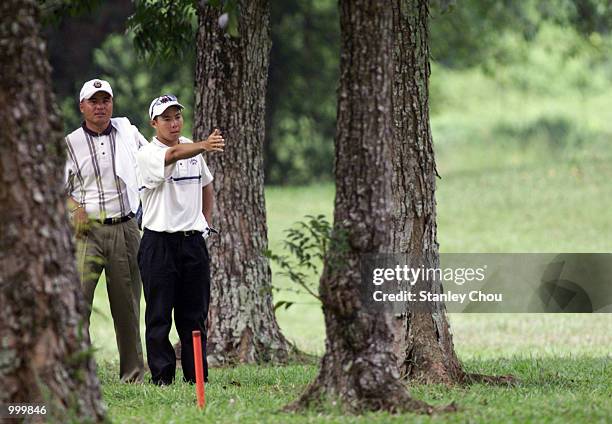 Lam Chih-Bing of Singapore discusses an option with team-mate Mardan Mamat in the rough during the Second Round of the Foursome Stroke Play during...