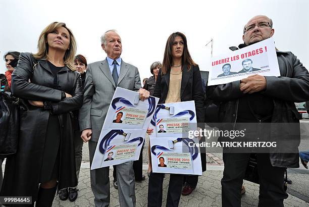 Journalists and European Parliament MPs including Sandrine Belier and Jean-Marie Cavada hold posters featuring the press cards of the two French...