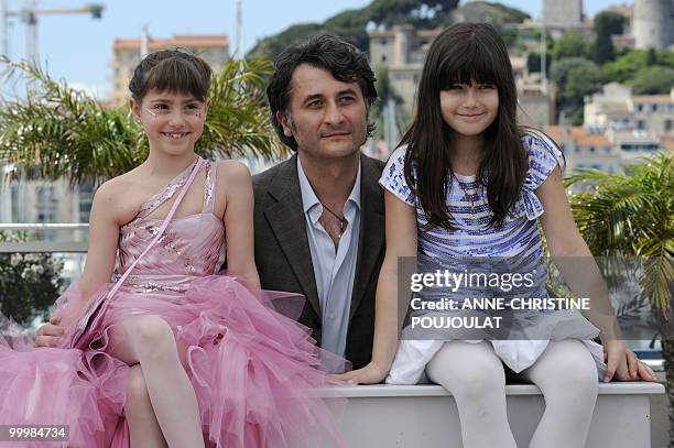 Romanian actor and director Cristi Puiu poses with actress Carmela Culda and actress Ileana Puiu during the photocall of "Aurora" presented in the Un...