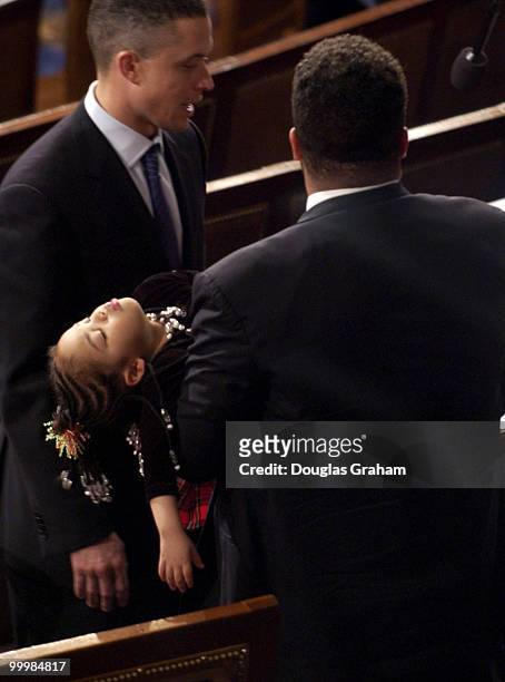 Jesse L. Jackson Jr., D-Il., talks with Harold Ford, D-TN., as his daughter Jessica Jackson sleeps after the State of the Union address. Jessica is 3...