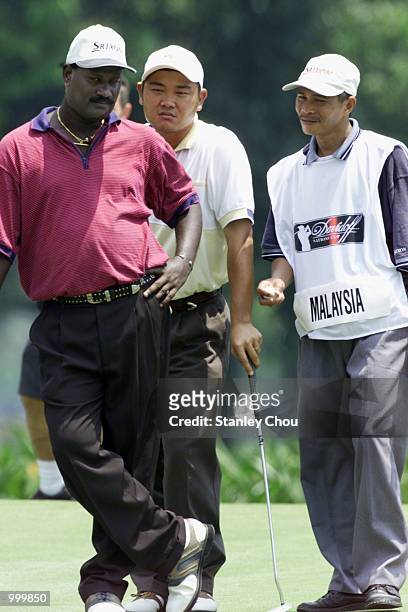 Gunasegaran and Danny Yap of Malaysia having a discussion while their Caddie looks on at the 17th hole during the Second Round of the Foursome Stroke...