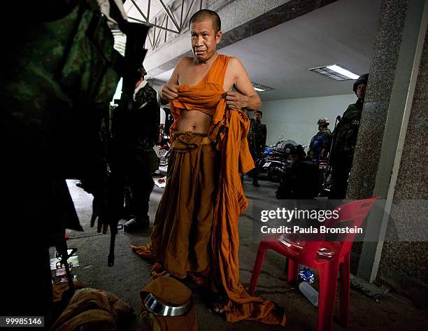 Thai Buddist monk is searched by soldiers who suspect him of being a red shirt anti-government protester inside the red shirt camp on May 19, 2010 in...