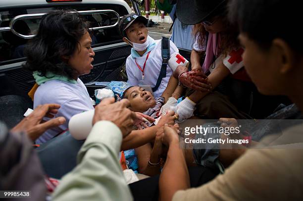Thai anti-government red shirt protester is attended to by medics after being shot by the Thai military while aiding a wounded comrade on May 19,...