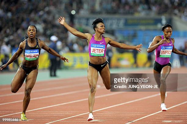 Carmelita Jeter of the US crosses the finish line ahead of Jamaica's Veronica Campbell-Brown and Sherone Simpson in the women's 100 meter event of...