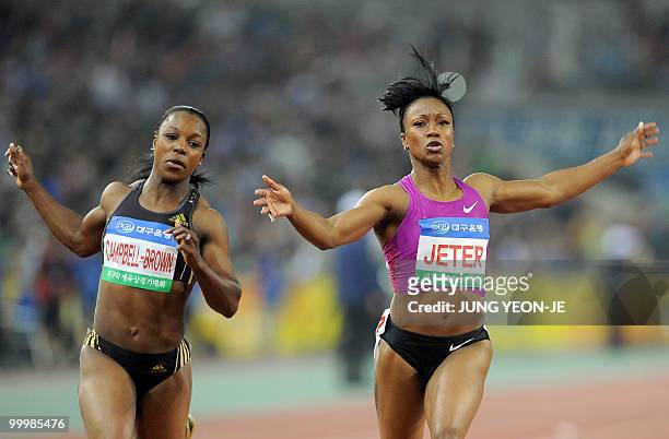 Carmelita Jeter of the US crosses the finish line ahead of Jamaica's Veronica Campbell-Brown in the women's 100 meter event of the Daegu...