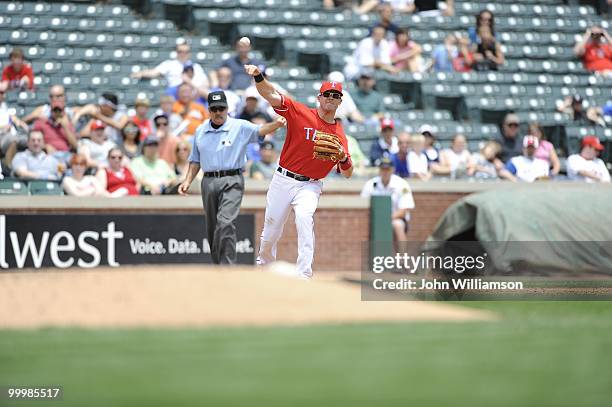 Third baseman Michael Young of the Texas Rangers fields his position as he throws to first base after catching a ground ball during the game against...