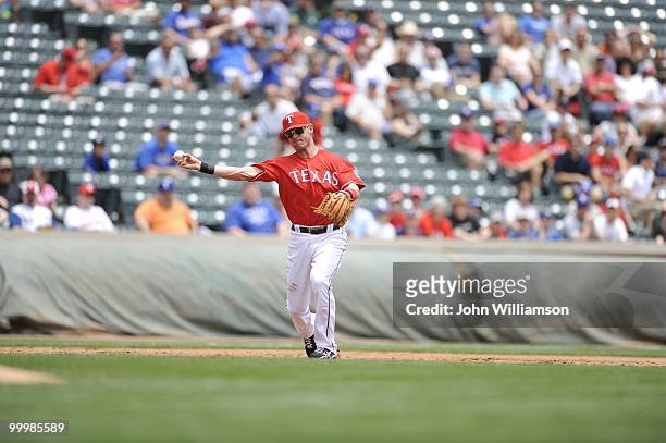 Third baseman Michael Young of the Texas Rangers fields his position as he throws to first base after catching a ground ball during the game against...