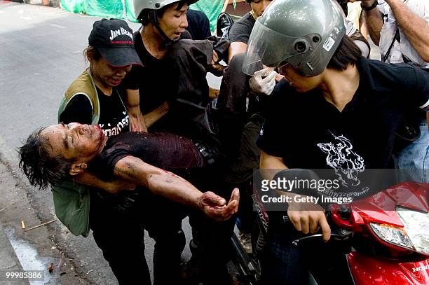 Thai anti-government red shirt protester is loaded onto the back of a motorcycle after being shot by Thai military forces on May 19, 2010 in Bangkok,...