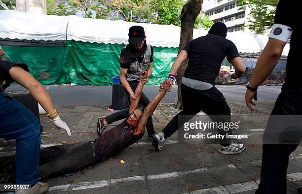Thai anti-government red shirt protester is dragged to safety after being shot by Thai military forces on May 19, 2010 in Bangkok, Thailand. At least...