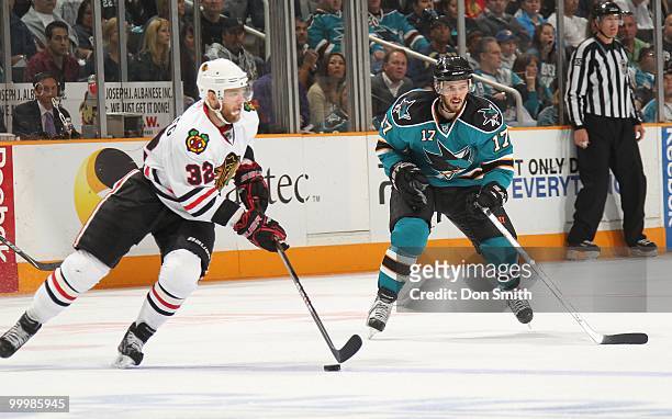 Kris Versteeg of the Chicago Blackhawks moves the puck around Torrey Mitchell of the San Jose Sharks in Game One of the Western Conference Finals...