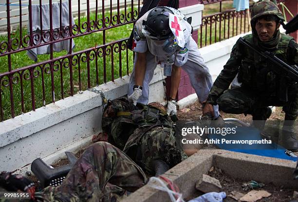 Thai security forces attempt to help a Thai soldier hit by a grenade on May 19, 2010 in Bangkok, Thailand. At least 5 people are reported to have...