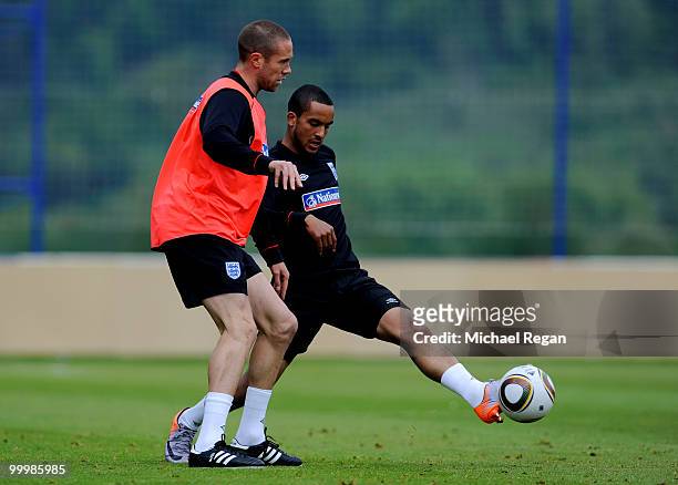 Matthew Upson is challenged by Theo Walcott during an England training session on May 19, 2010 in Irdning, Austria.