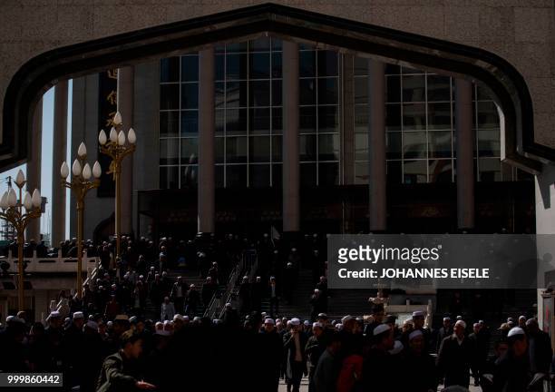 This picture taken on March 2, 2018 shows ethnic Hui Muslim men leaving Laohuasi Mosque after Friday prayers in Linxia, China's Gansu province. -...