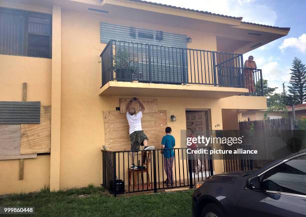 Juan Oviendo , Jonathan Oviendo and Ana Rodriguez nail wood to their house before the arrival of hurricane 'Irma' in Little Havana, Miami, US, 8...