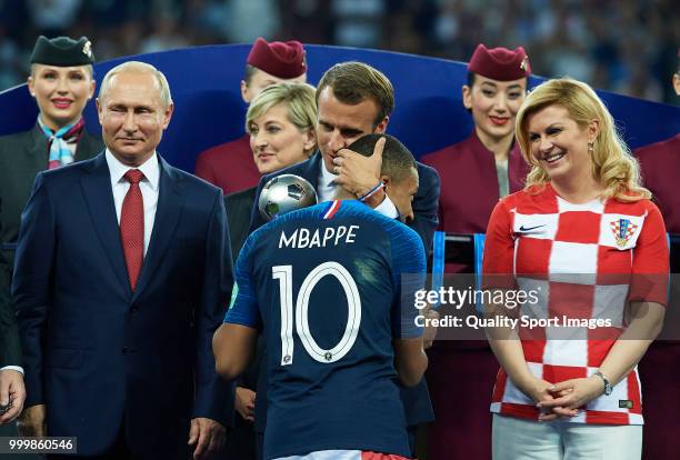 French President Emmanuel Macron embraces Kylian Mbappe of France as Russian President Vladimir Putin looks on after the 2018 FIFA World Cup Russia...