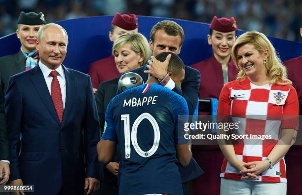 French President Emmanuel Macron embraces Kylian Mbappe of France as Russian President Vladimir Putin looks on after the 2018 FIFA World Cup Russia...