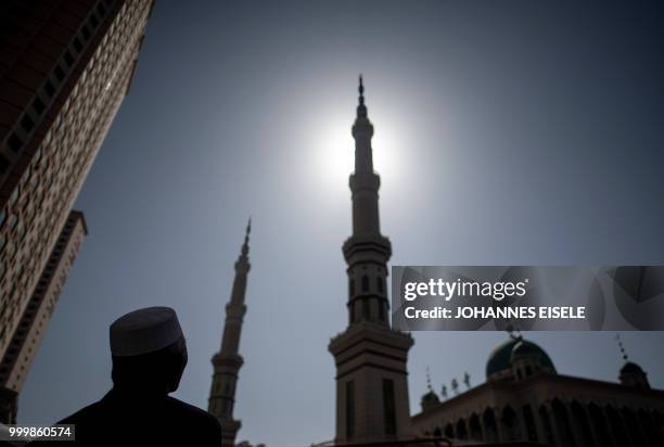 This picture taken on March 2, 2018 shows an ethnic Hui Muslim man standing in front of Laohuasi Mosque after Friday prayers in Linxia, China's Gansu...