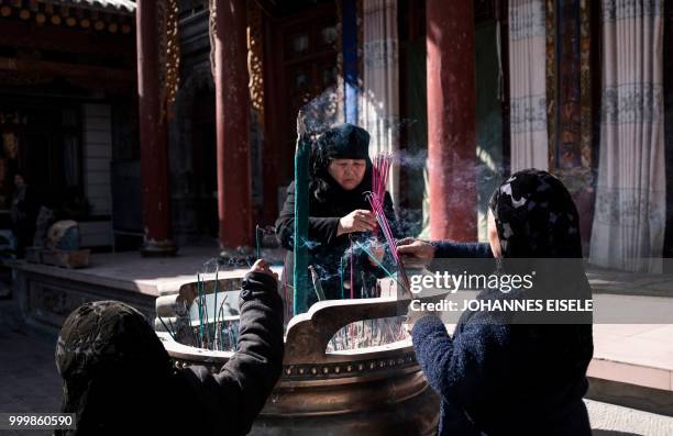 This picture taken on March 2, 2018 shows ethnic Hui Muslim women praying in a courtyard at a religious site in Linxia, China's Gansu province. -...