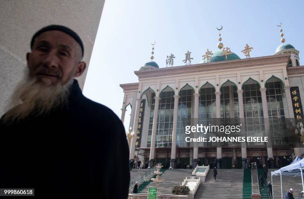 This picture taken on March 2, 2018 shows ethnic Hui Muslim men arriving at Laohuasi Mosque for Friday prayers in Linxia, China's Gansu province. -...