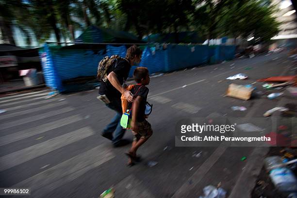 Tourist and A child run for a cover on May 19, 2010 in Bangkok, Thailand. Protesters have clashed with military forces for five consecutive day in...