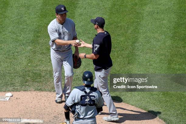 New York Yankees starting pitcher Masahiro Tanaka hands the baseball to New York Yankees manager Aaron Boone as he leaves the game during the seventh...