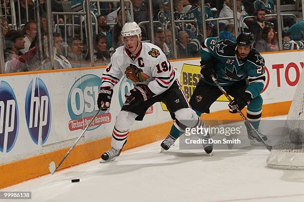 Jonathan Toews of the Chicago Blackhawks handles the puck behind the net away from Manny Malhotra of the San Jose Sharks in Game One of the Western...