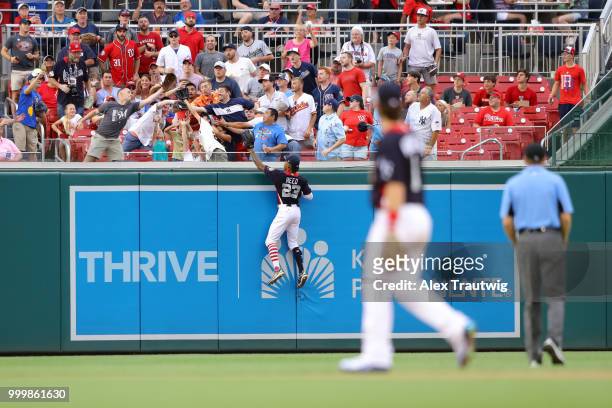 Buddy Reed of Team USA climbs the wall in an attempt to catch a Yusniel Diaz of the World Team home run reach the stands during the SiriusXM All-Star...