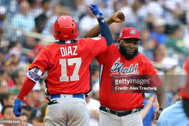 Yusniel Diaz of the World Team is greeted by David Ortiz after hitting a home run during the SiriusXM All-Star Futures Game at Nationals Park on...
