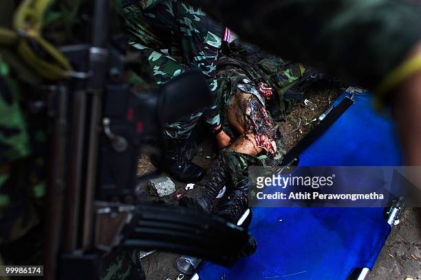 Thai security forces attempt to help a Thai soldier hit by a grenade on May 19, 2010 in Bangkok, Thailand. At least 5 people are reported to have...