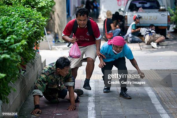 Thai anti-government red shirt protesters run for cover as Thai military forces advance on their position on May 19, 2010 in Bangkok, Thailand. At...