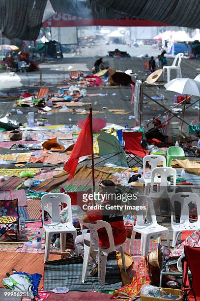 Lone Thai anti-government red shirt protester sits in the abandoned main rally site after Thai military forces moved in and protest leaders ended the...
