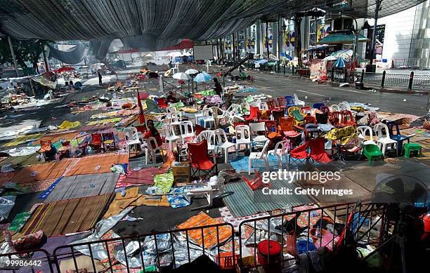 Lone Thai anti-government red shirt protester sits in the abandoned main rally site after Thai military forces moved in and protest leaders ended the...