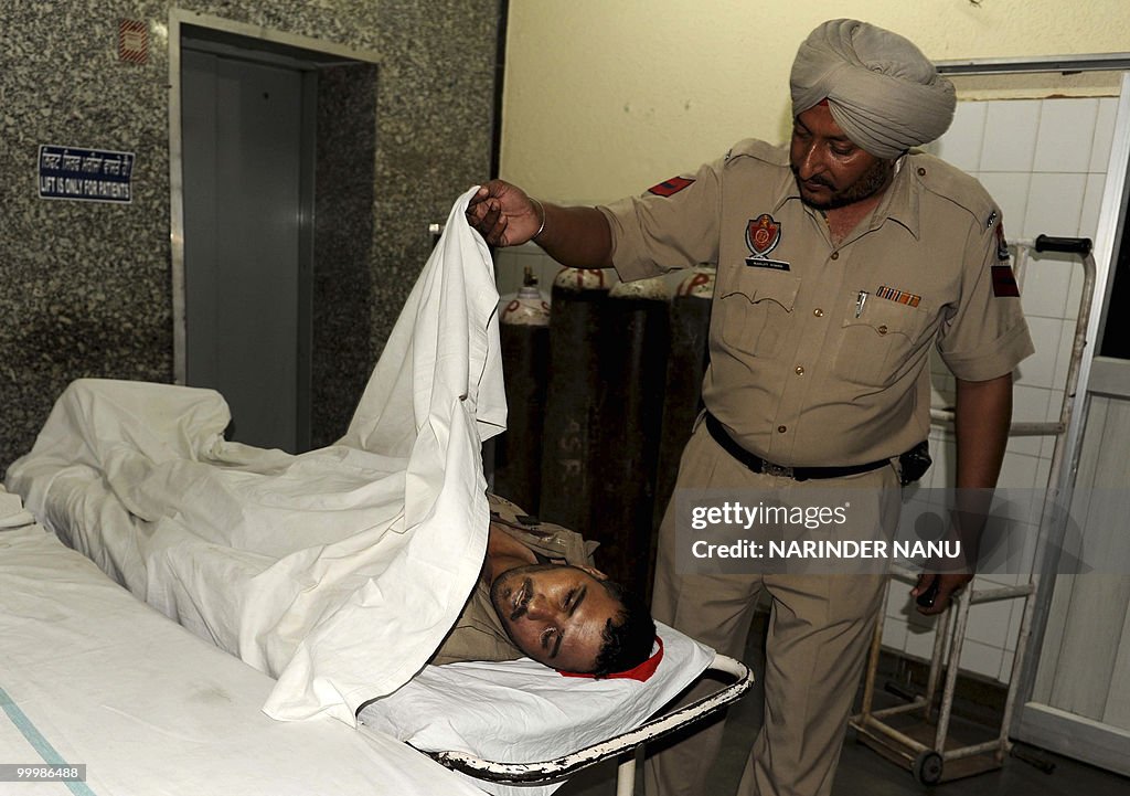 An Indian policeman looks at the body of