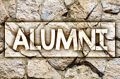 Writing note showing  Alumni. Business photo showcasing Alum Old graduate Postgraduate Gathering College Academy Celebration Ideas message stone stones rock rocks backgrounds wild natural pebbles.