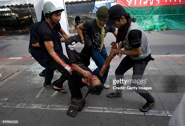 Thai anti-government red shirt protester is dragged to safety after being shot by Thai military forces on May 19, 2010 in Bangkok, Thailand. At least...
