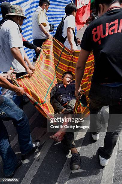 Thai anti-government red shirt protester is carried to medics after being shot by Thai military forces on May 19, 2010 in Bangkok, Thailand. At least...