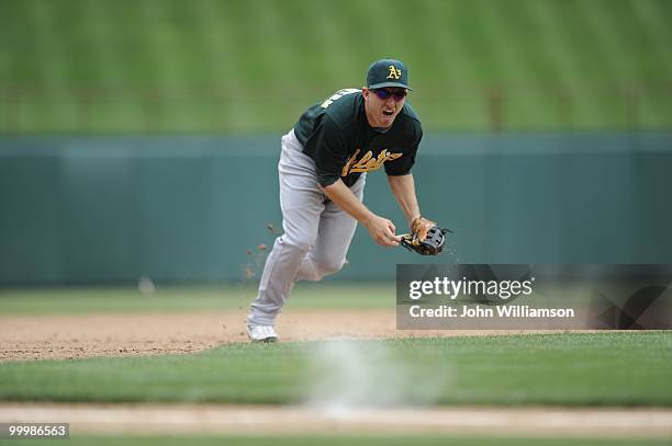 Shortstop Cliff Pennington of the Oakland Athletics fields his position as he catches a ground ball with the infield in and looks to throw home as...