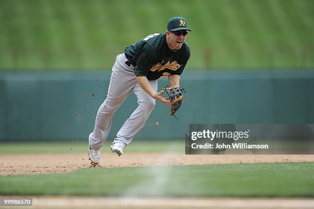 Shortstop Cliff Pennington of the Oakland Athletics fields his position as he catches a ground ball with the infield in and looks to throw home as...