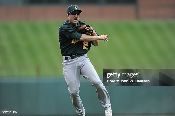 Shortstop Cliff Pennington of the Oakland Athletics fields his position as he throws home to catch the baserunner from third base trying to score...