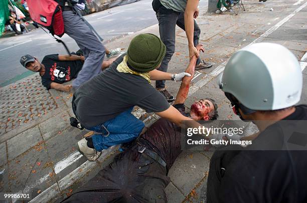 Thai anti-government red shirt protester is dragged to safety after being shot by Thai military forces on May 19, 2010 in Bangkok, Thailand. At least...