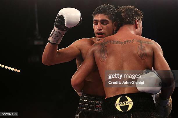 Amir Khan of Great Britain embraces Paulie Malignaggi after defeating him in the WBA light welterweight title fight at Madison Square Garden on May...