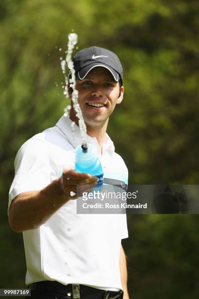 Paul Casey of England squirts his drinks bottle at photographer during the Pro-Am round prior to the BMW PGA Championship on the West Course at...