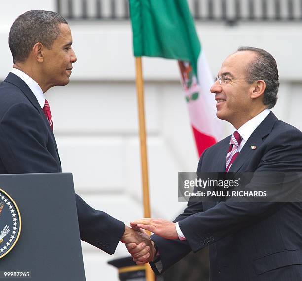 President Barack Obama and Mexican President Felipe Calderon shake hands during their speeches at State Arrival ceremonies for the Mexican President...