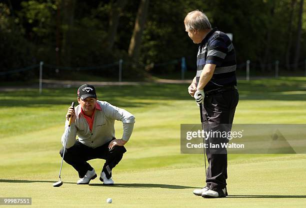 Graham Otway chats to Graeme McDowell of Northern Ireland during the Pro-Am round prior to the BMW PGA Championship on the West Course at Wentworth...