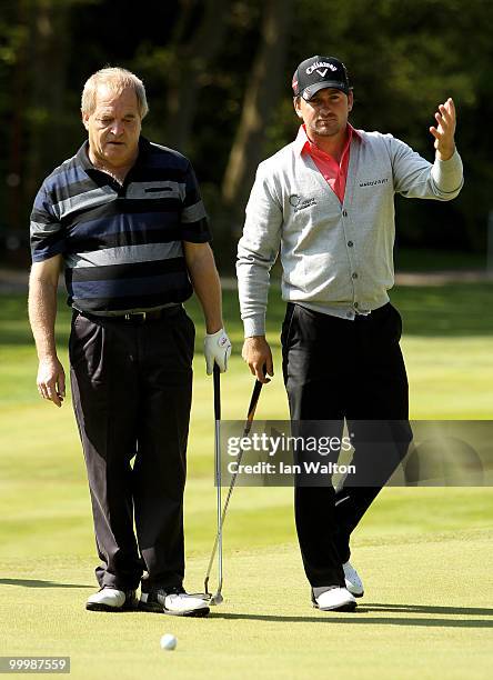 Graham Otway lines up a putt with Graeme McDowell of Northern Ireland during the Pro-Am round prior to the BMW PGA Championship on the West Course at...