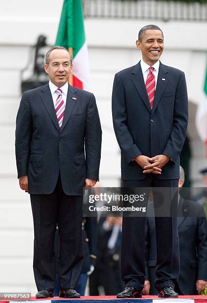 President Barack Obama, right, and Felipe Calderon, Mexico's president, stand during an official state arrival on the South Lawn of the White House...