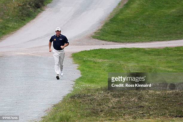 Lee Westwood of England runs to the next hole during the Pro-Am round prior to the BMW PGA Championship on the West Course at Wentworth on May 19,...