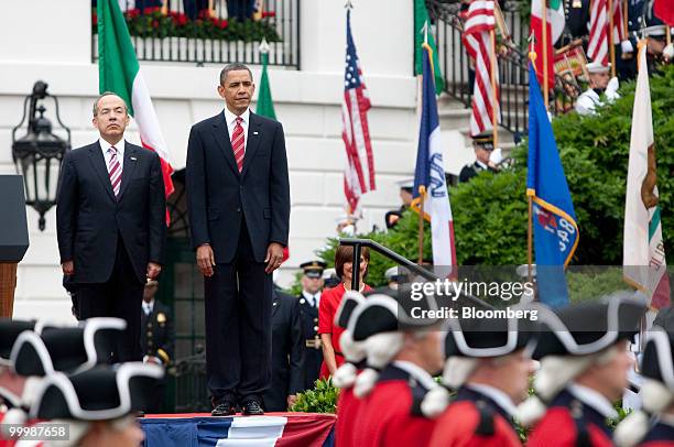 President Barack Obama, right, and Felipe Calderon, Mexico's president, review the troops during an official state arrival on the South Lawn of the...