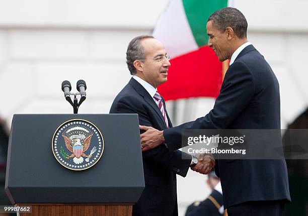 President Barack Obama, right, speaks to Felipe Calderon, Mexico's president, during an official state arrival on the South Lawn of the White House...